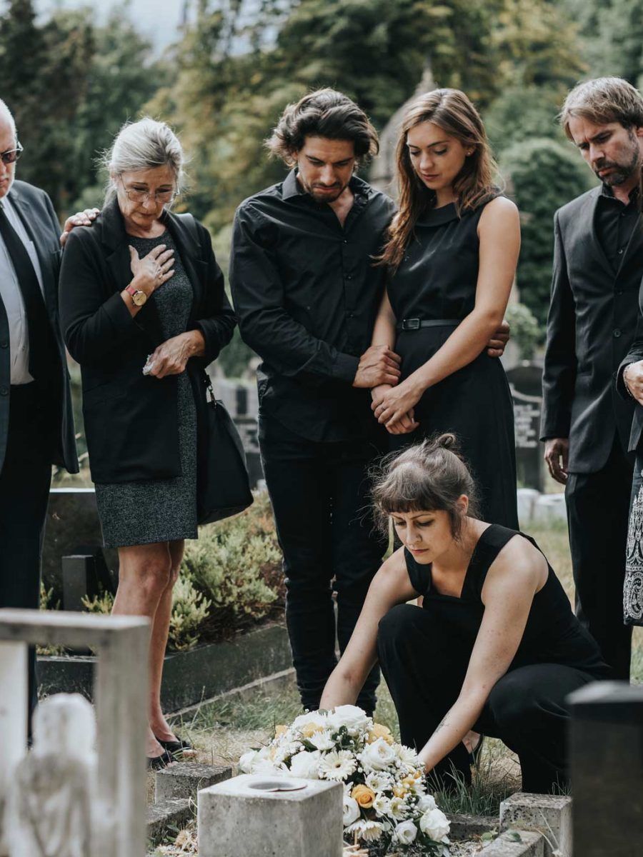 family-laying-flowers-on-the-grave-QKURHPX.jpg