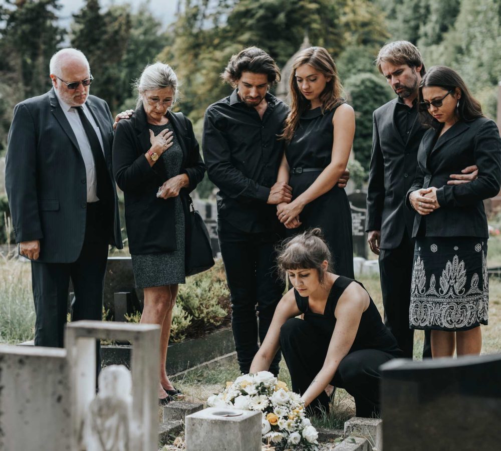 family-laying-flowers-on-the-grave-QKURHPX.jpg